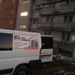 Józef Bobula - P.P.H.U BUD-MAX - Budynek w trakcie remontu z rusztowaniami, na pierwszym planie samochód firmy remontowej 'BUD max BUDOWLANA' z numerem telefonu, widoczne gruz i teren budowy.