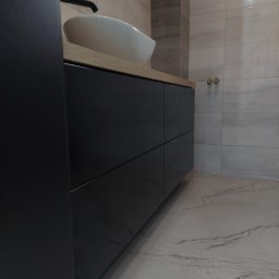 ARCHITON SPÓŁKA Z OGRANICZONĄ ODPOWIEDZIALNOŚCIĄ - Nowoczesna łazienka: czarna szafka pod umywalkę z blatem z jasnego drewna, biała umywalka nablatowa, marmurowe płytki na podłodze i ścianie. Minimalistyczny design.