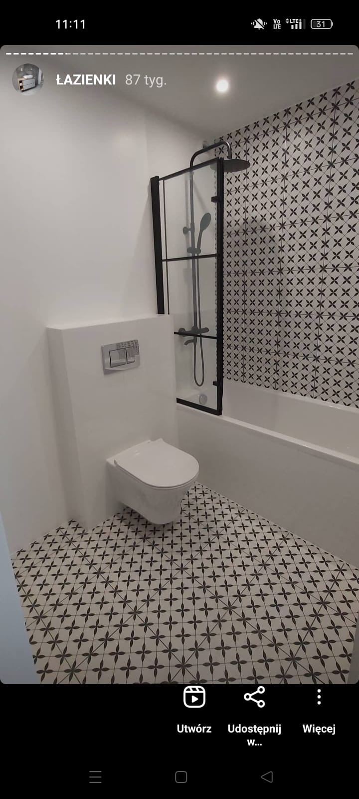 Nowoczesna łazienka z wiszącą toaletą, czarną kabiną prysznicową typu walk-in, białą wanną i wzorzystymi płytkami podłogowymi oraz ściennymi.