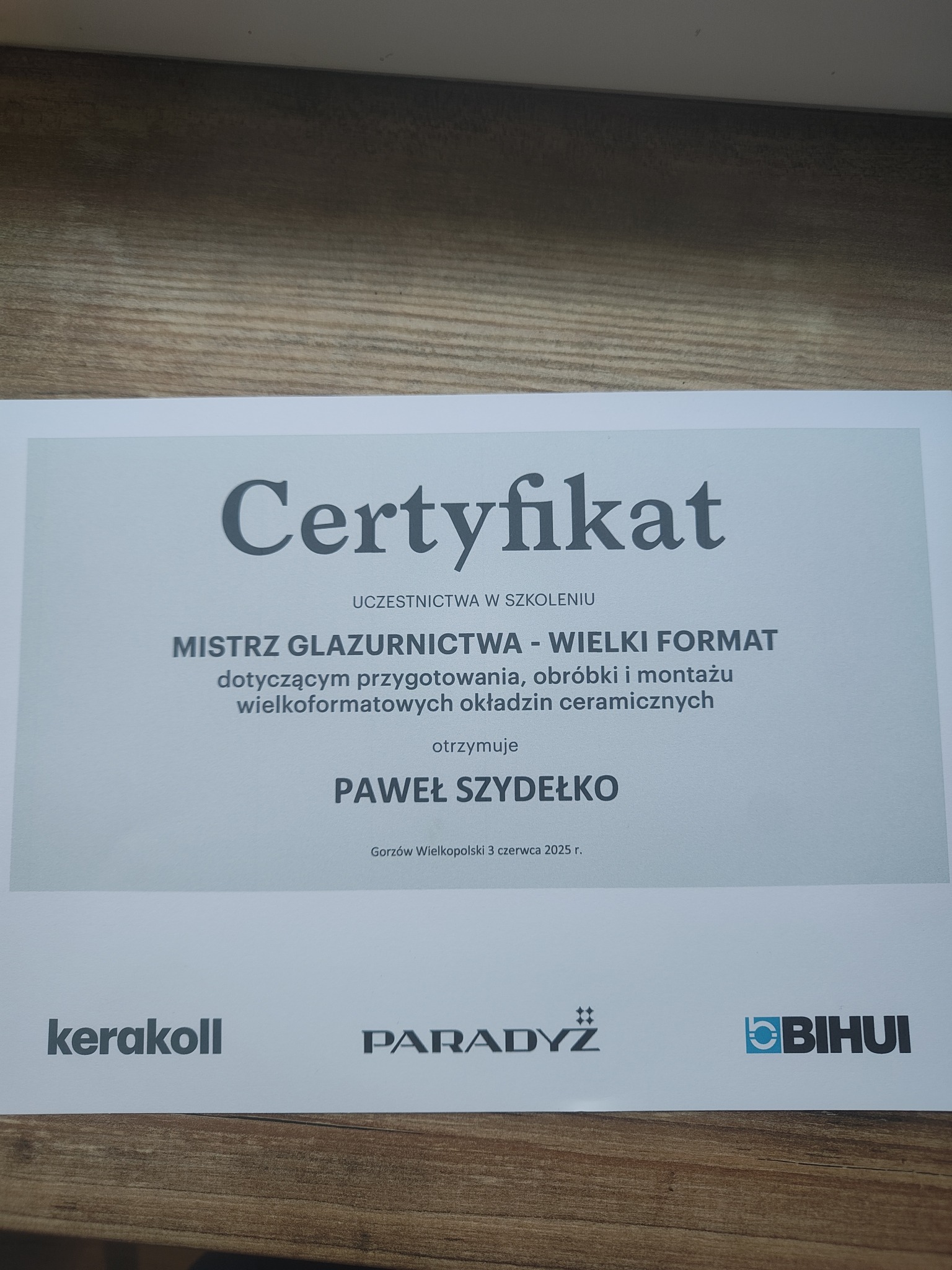 Certyfikat mistrza glazurnictwa wielkiego formatu dla Pawła Szydełko, datowany na 3 czerwca 2025, z logotypami Kerakoll, Paradyż i BIHUI.