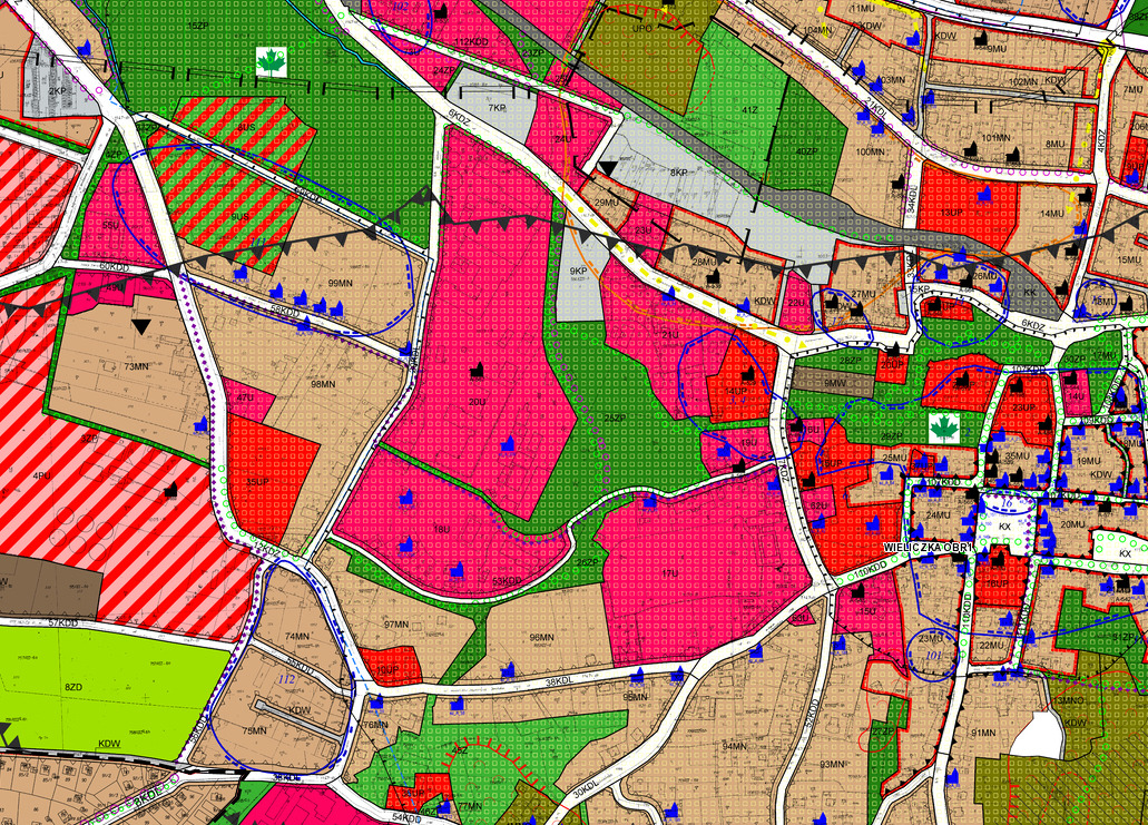 Mapa geodezyjna z kolorowymi oznaczeniami działek, budynków i dróg, z widocznymi numerami ewidencyjnymi i symbolami graficznymi.