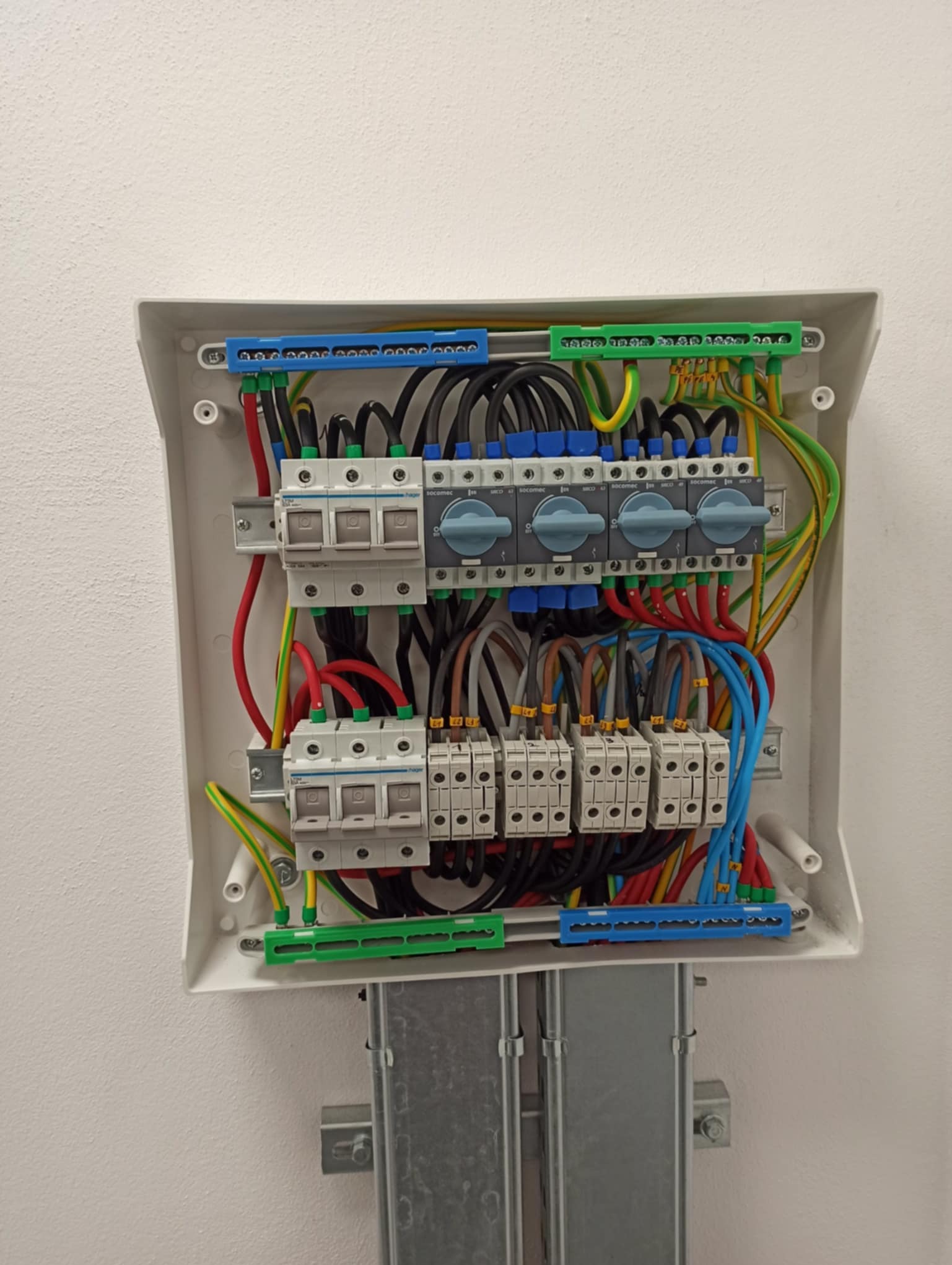 Rozdzielnica elektryczna z precyzyjnie ułożonymi przewodami, widoczne zabezpieczenia i wyłączniki. Estetyczne i funkcjonalne rozwiązanie instalacji elektrycznej.