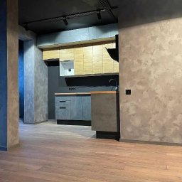 D&L remont - Nowoczesna kuchnia z drewnianymi i szarymi szafkami, szarą ścianą z efektem dekoracyjnym i drewnianą podłogą, oświetlona reflektorami sufitowymi.