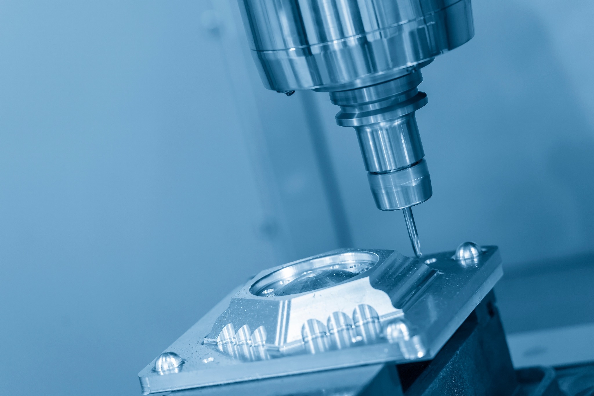 Precyzyjna obróbka metalu na maszynie CNC, tworzenie formy z widocznymi śladami chłodziwa.