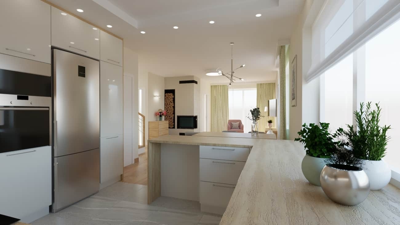 Nowoczesna, otwarta kuchnia z białymi szafkami, szarym blatem i wyspą, z widokiem na salon z kominkiem i jasnymi zasłonami, oświetlona światłem dziennym wpadającym przez duże okno z roślinami...