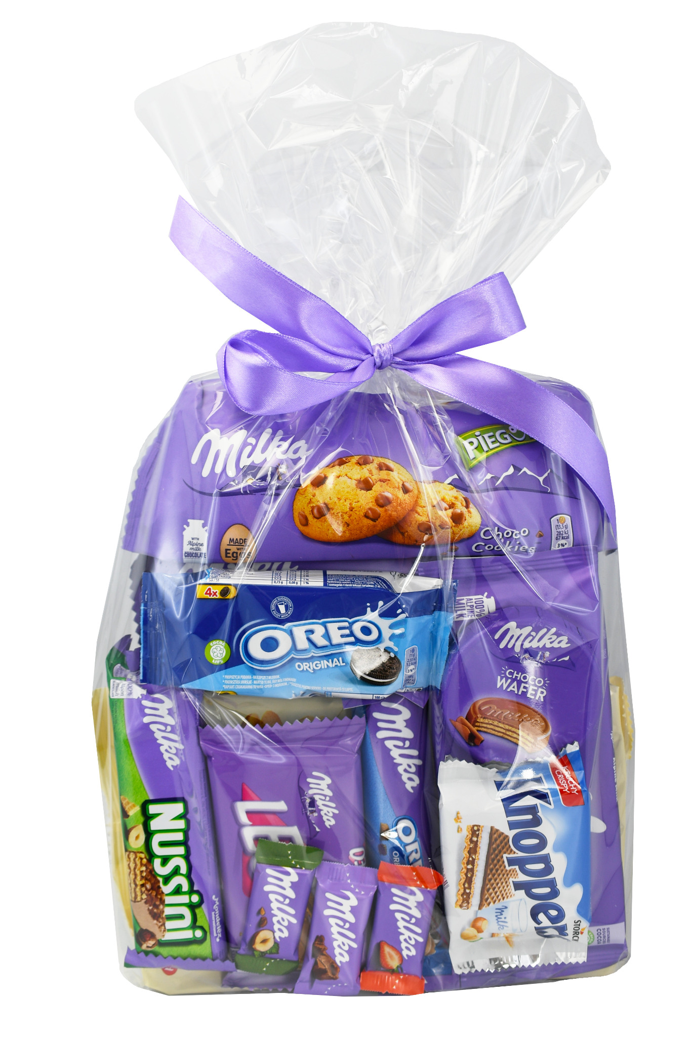Koszyk prezentowy wypełniony słodyczami Milka, Oreo i Knoppers, owinięty przezroczystą folią i przewiązany fioletową wstążką.