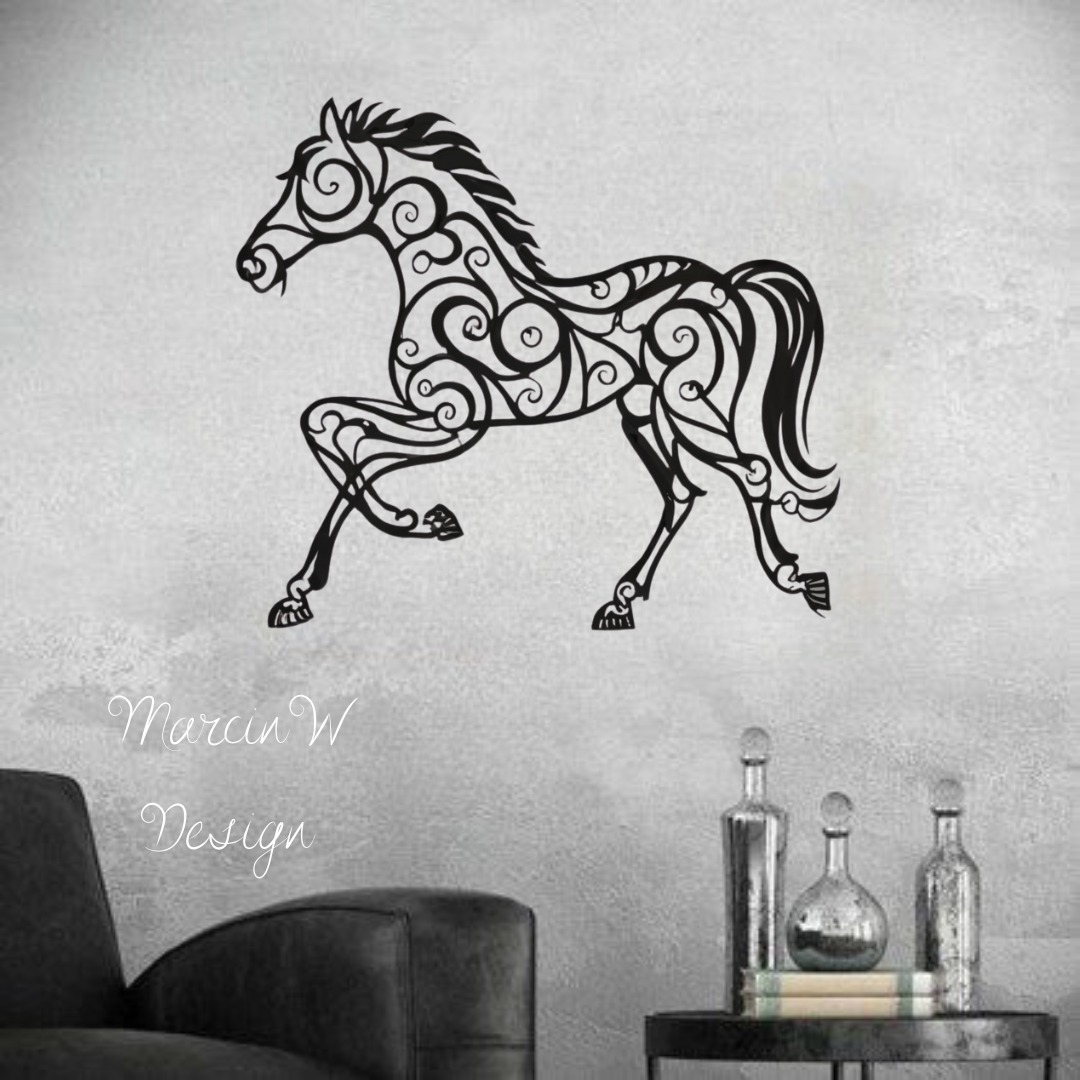 Czarny, ażurowy wzór konia na szarej ścianie, poniżej podpis 'Marcin W Design', obok fragment czarnego fotela i stolik z dekoracyjnymi butelkami.