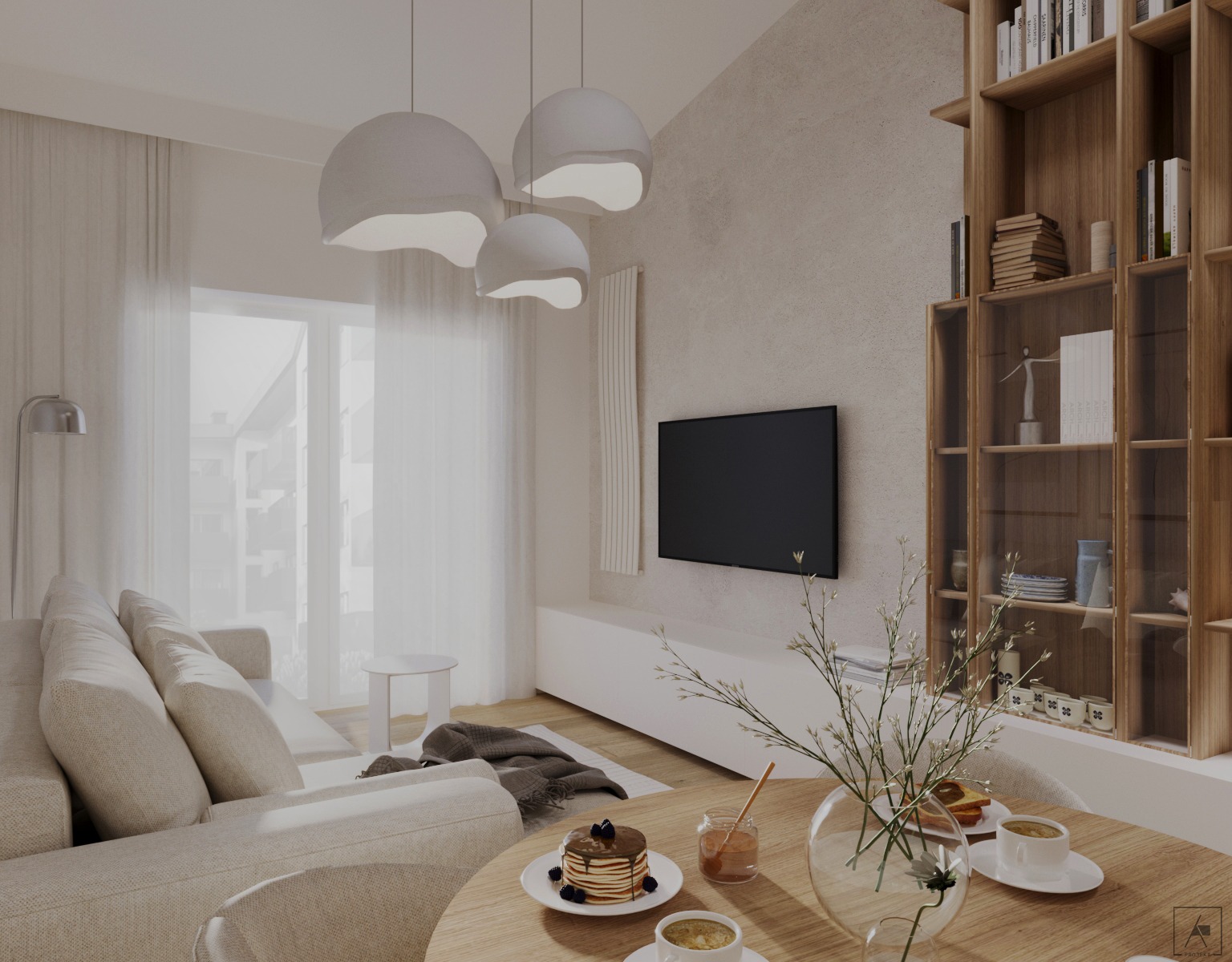 Jasny salon z aneksem kuchennym w neutralnych barwach. Widoczny narożnik z poduszkami, drewniany regał z przeszklonymi półkami, okrągły stół z deserem i kawą, oraz trzy designerskie lampy wiszące.