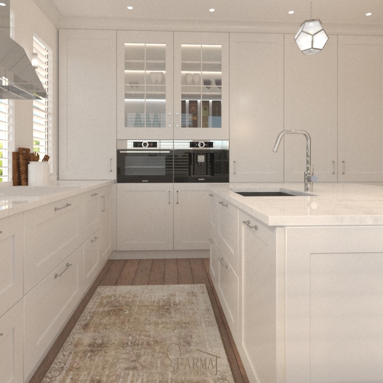 Jasna kuchnia w stylu klasycznym z białymi szafkami, drewnianą podłogą i dywanem w beżowych odcieniach. Widoczne wbudowane urządzenia: piekarnik i ekspres do kawy. Nad blatem wisząca lampa...