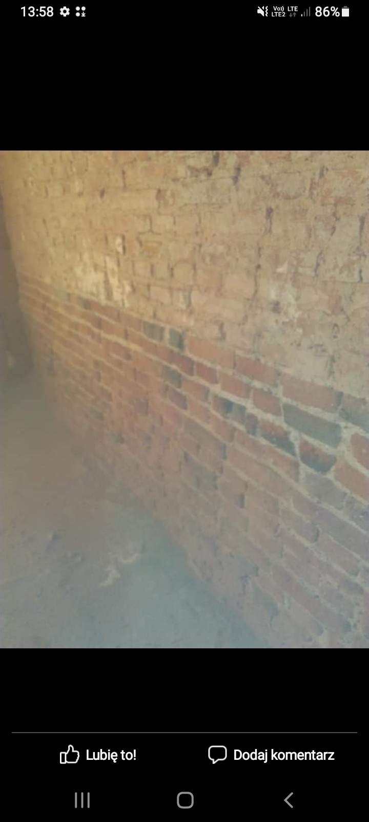 Ceglana ściana z widocznymi śladami zabrudzeń w Zduńskiej Woli, prawdopodobnie przed czyszczeniem lub renowacją.