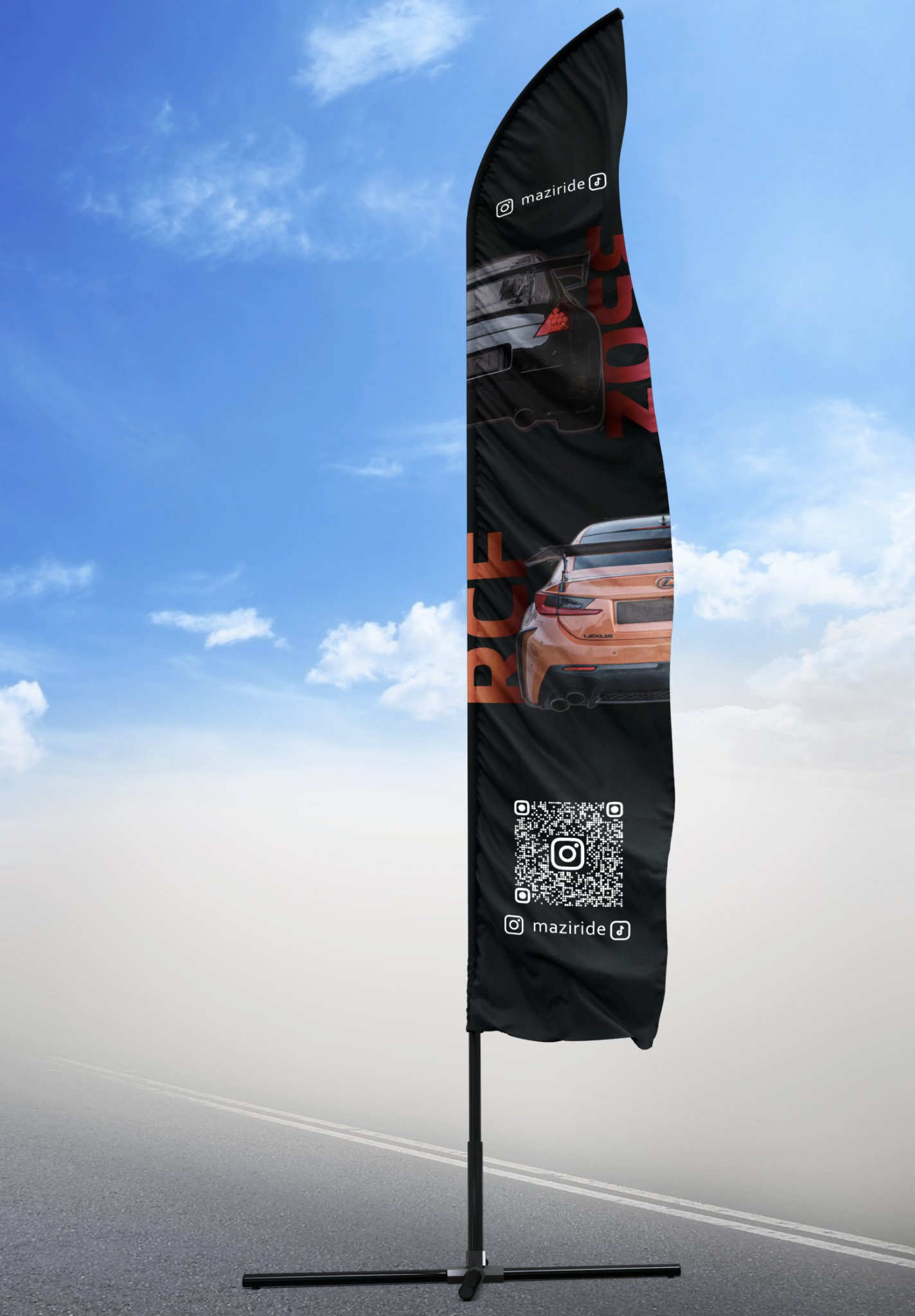 Wysoki, czarny, łukowaty baner reklamowy z grafiką dwóch samochodów od tyłu, kodem QR i logotypem marki, umieszczony na stojaku na tle błękitnego nieba i szarej drogi.