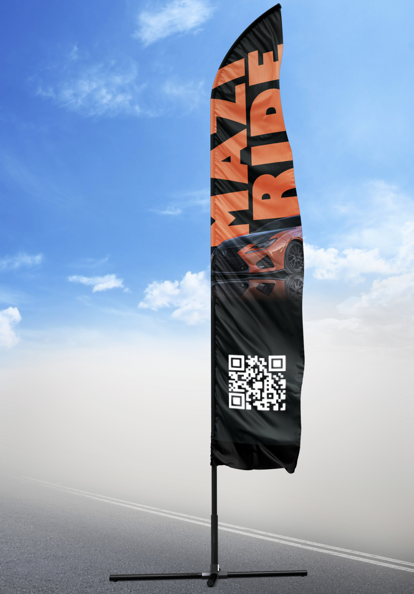 Wysoki, czarny, reklamowy beachflag z pomarańczowym napisem 'MAKE RIDE' i zdjęciem sportowego samochodu oraz kodem QR, ustawiony na tle błękitnego nieba z chmurami i szarej drogi.