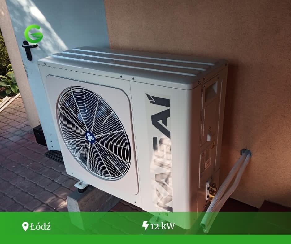 Zewnętrzna jednostka pompy ciepła Kaisai o mocy 12kW, zamontowana przy ścianie budynku z widocznymi przewodami chłodniczymi i elementami montażowymi.