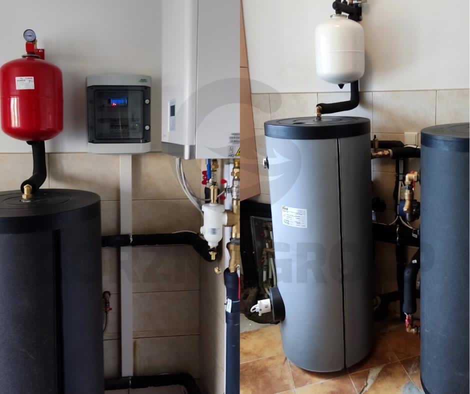 Instalacja z dwoma szarymi zbiornikami buforowymi, czerwonym i białym naczyniem wzbiorczym oraz skrzynką sterowniczą na ścianie wyłożonej płytkami w beżowym odcieniu.