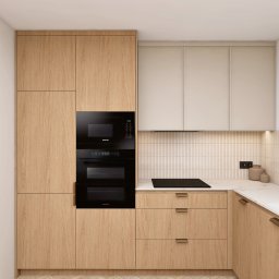 Cholewa - Interior Design Concept - Nowoczesna kuchnia z drewnianymi frontami, czarnym piekarnikiem i płytą indukcyjną. Uwagę przykuwają beżowe płytki na ścianie i marmurowy blat.