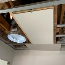 Montaż sufitu podwieszanego z płyt karton gips z widoczną wentylacją w przestrzeni nad sufitem.