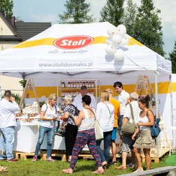 Stoll Silesia s.c. - Stoisko firmy Stoll do smaku z produktami na zewnątrz, otoczone klientami, z białymi balonami i logo firmy na namiocie oraz ścianie bocznej.