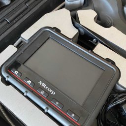 WaterLeak.pl - Osuszanie Budynków Wykrywanie Wycieków Wody Wynajem Osuszaczy Lokalizacja Przecieków Gdynia Gdańsk Sopot Warszawa - Urządzenie Mitcorp z ekranem i przyciskami funkcyjnymi, w sztywnym futerale, używane do wykrywania wycieków i inspekcji hydraulicznych.