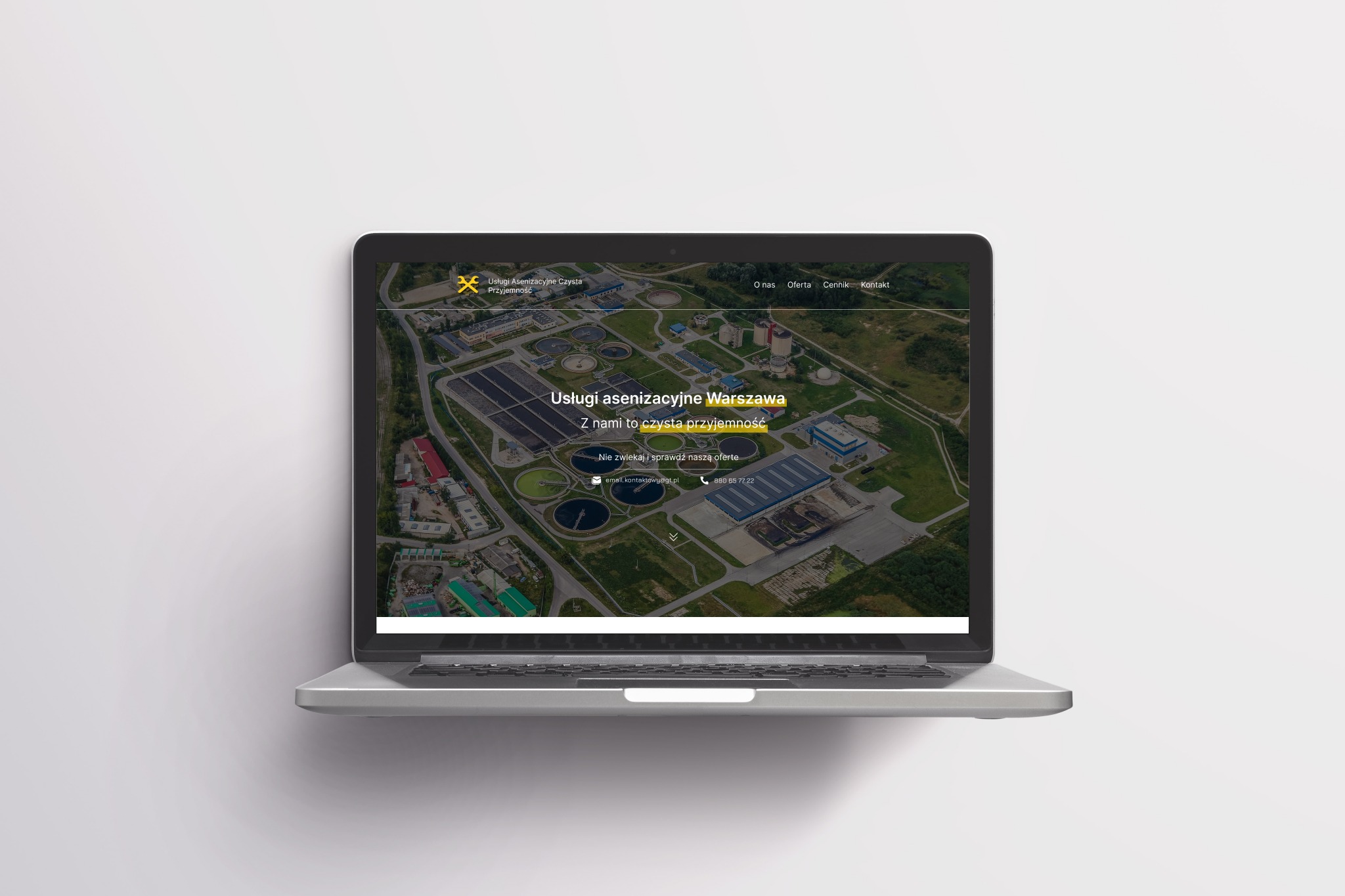 Laptop wyświetla stronę internetową firmy świadczącej usługi asenizacyjne w Warszawie, prezentującą widok z lotu ptaka na oczyszczalnię ścieków.