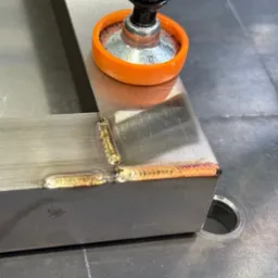 Spoina na profilu zamkniętym, zabezpieczonym ściskiem stolarskim w Suchym Dębie. Widoczne tęczowe zabarwienia na spoinie.