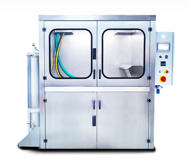 Profesjonalna, przemysłowa myjka ciśnieniowa ze stali nierdzewnej z przezroczystymi drzwiami, widocznymi wężami i panelem sterowania z przyciskiem awaryjnym.