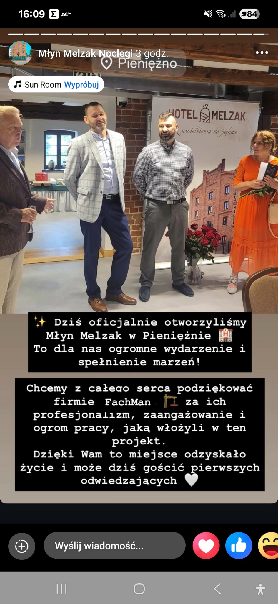 Uroczyste otwarcie Młyna Melzak w Pieniężnie. Grupa osób na tle plakatu z budynkiem młyna. Podziękowania dla firmy FachMan za profesjonalizm i zaangażowanie.