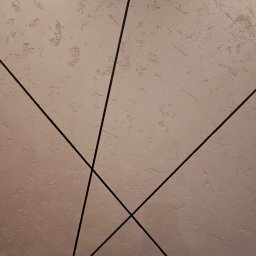 IVAN SHEVCHUK PRO100BUD - Teksturowana ściana w odcieniach beżu z geometrycznym wzorem z czarnych listew.