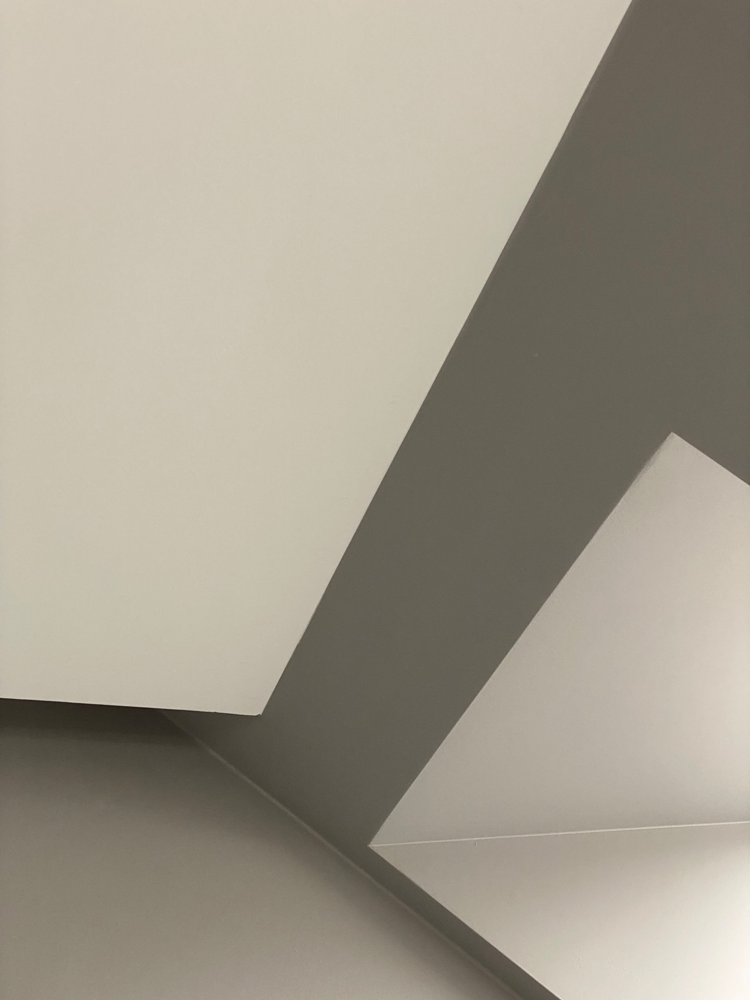 Pomieszczenie po malowaniu: biały sufit i szare ściany, widoczny fragment narożnika.