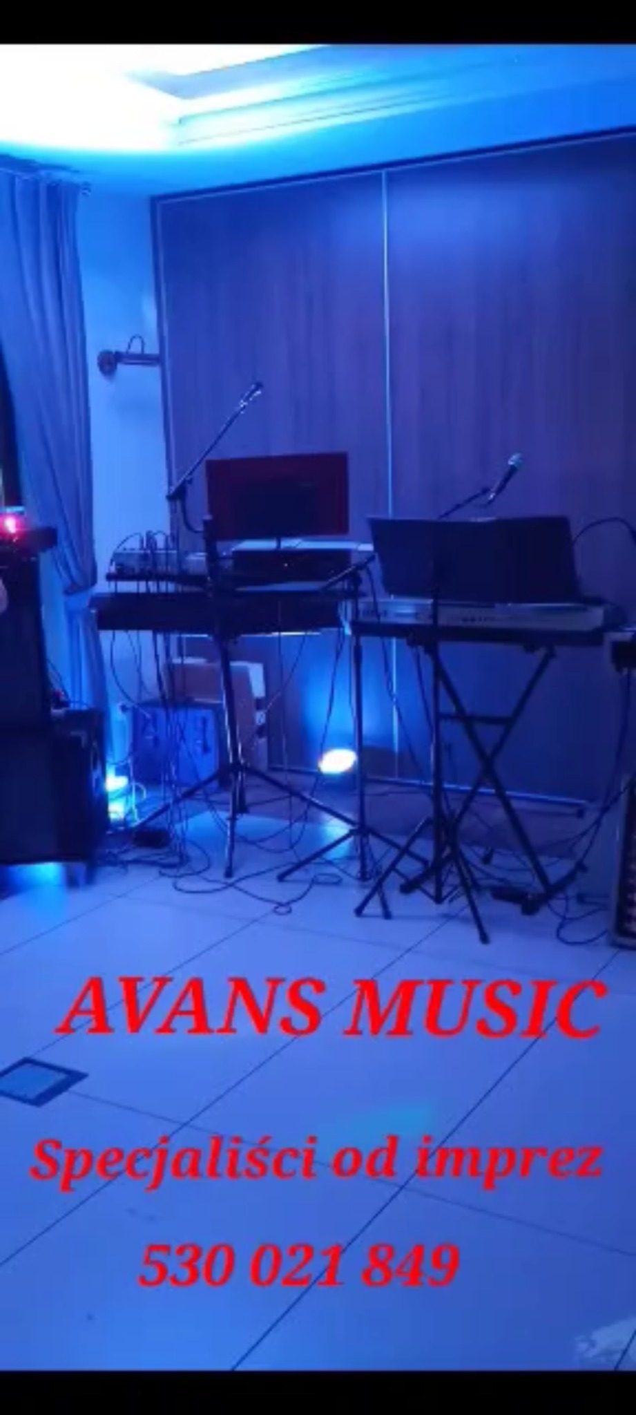 Scena z dwoma stanowiskami muzycznymi, klawiatury, monitory i mikrofony podświetlone niebieskim światłem, widoczne kable i statywy, na pierwszym planie napis 'AVANS MUSIC' i numer telefonu.