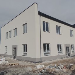 Usługi Ogólnobudowlane - Ukończony projekt ,Elewacja budynku szkolnego wraz z wykończeniami kafelkowymi wokół drzwi i spodem budynku.
