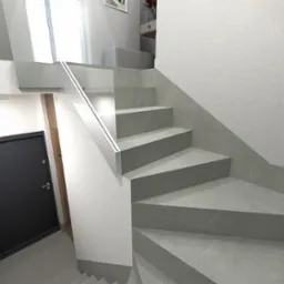 Wizualizacja schodów w nowoczesnym wnętrzu z czarnymi drzwiami po lewej stronie i minimalistycznym oświetleniem LED wzdłuż poręczy.