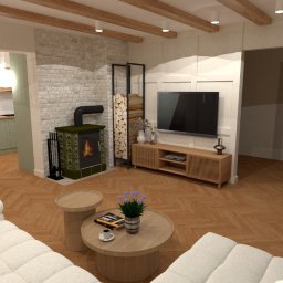 MZ InteriorDesign - Wnętrze salonu z kominkiem kaflowym, drewnianymi belkami stropowymi i parkietem w jodełkę. Widoczna kuchnia w tle i rośliny doniczkowe. Projekt w stylu rustykalnym.