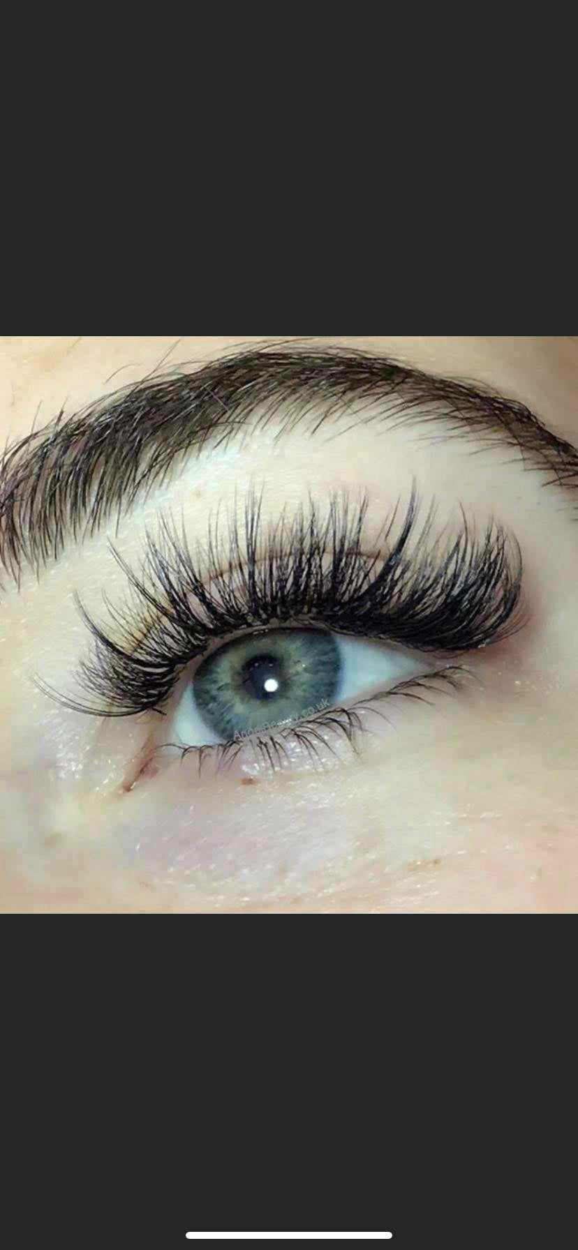 Zbliżenie na oko z przedłużonymi, gęstymi rzęsami w Pruszczu Gdańskim, podkreślające intensywny, zielono-szary kolor tęczówki i precyzyjną aplikację.
