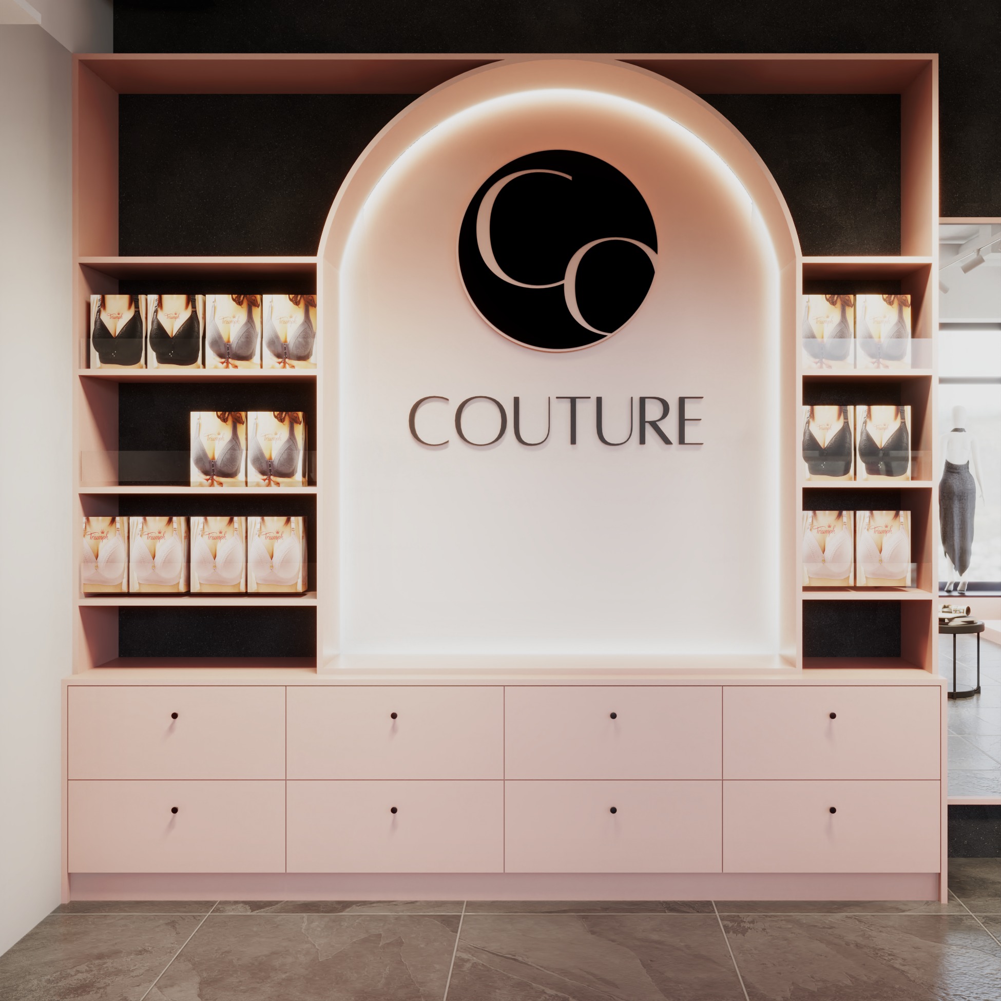 Różowa zabudowa meblowa z półkami na opakowania bielizny i logo 'Couture' w butiku. U dołu rząd szuflad z czarnymi gałkami. Minimalistyczny design.