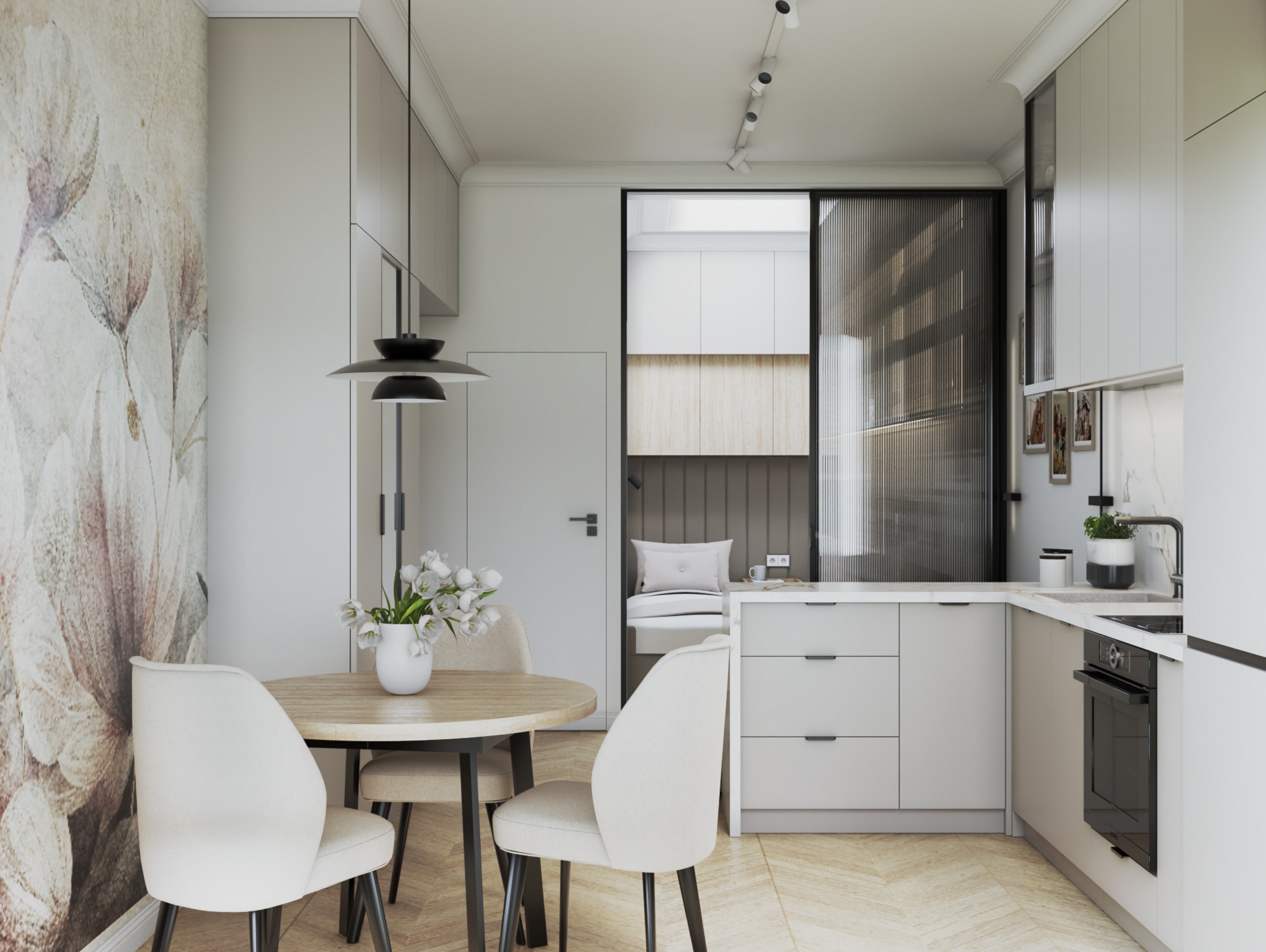 Jasna kuchnia z okrągłym stołem i kwiatami, widok na wnękę z miejscem do siedzenia za przesuwnymi drzwiami. Minimalistyczny design, neutralna kolorystyka i kwiatowy motyw na ścianie.