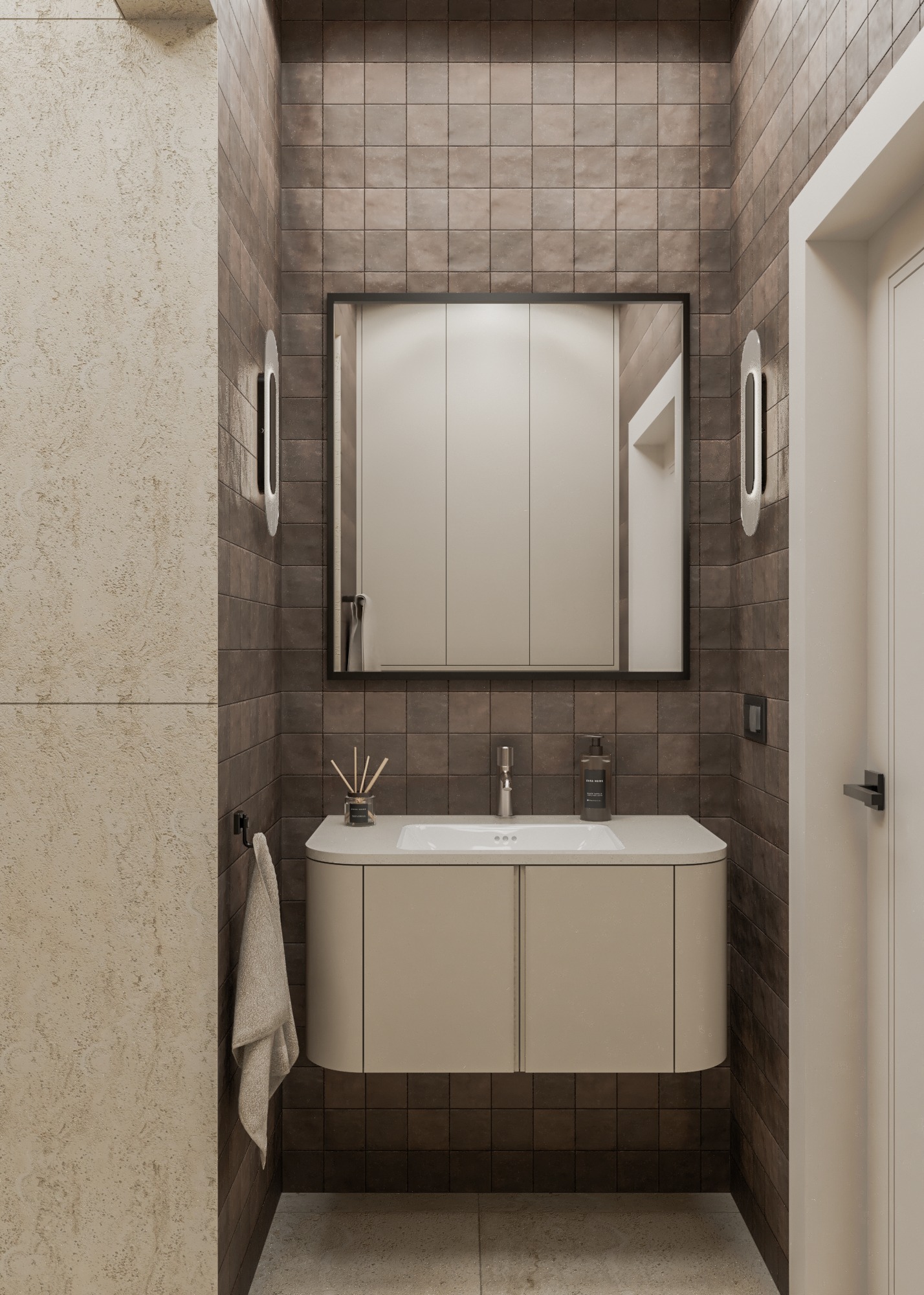 Nowoczesna łazienka z brązowymi płytkami, beżową szafką pod umywalką i lustrem w czarnej ramie. Minimalistyczne oświetlenie i beżowy ręcznik.