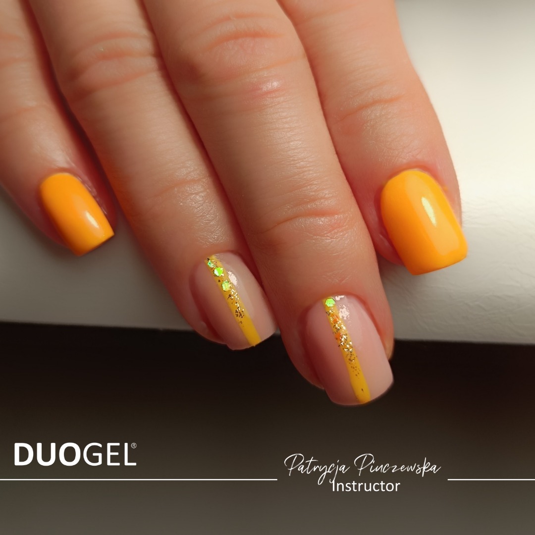 Żółty manicure hybrydowy z brokatowymi paskami na beżowym tle, widoczny logo DUOGEL oraz imię i nazwisko instruktora Patrycja Pinczewska.