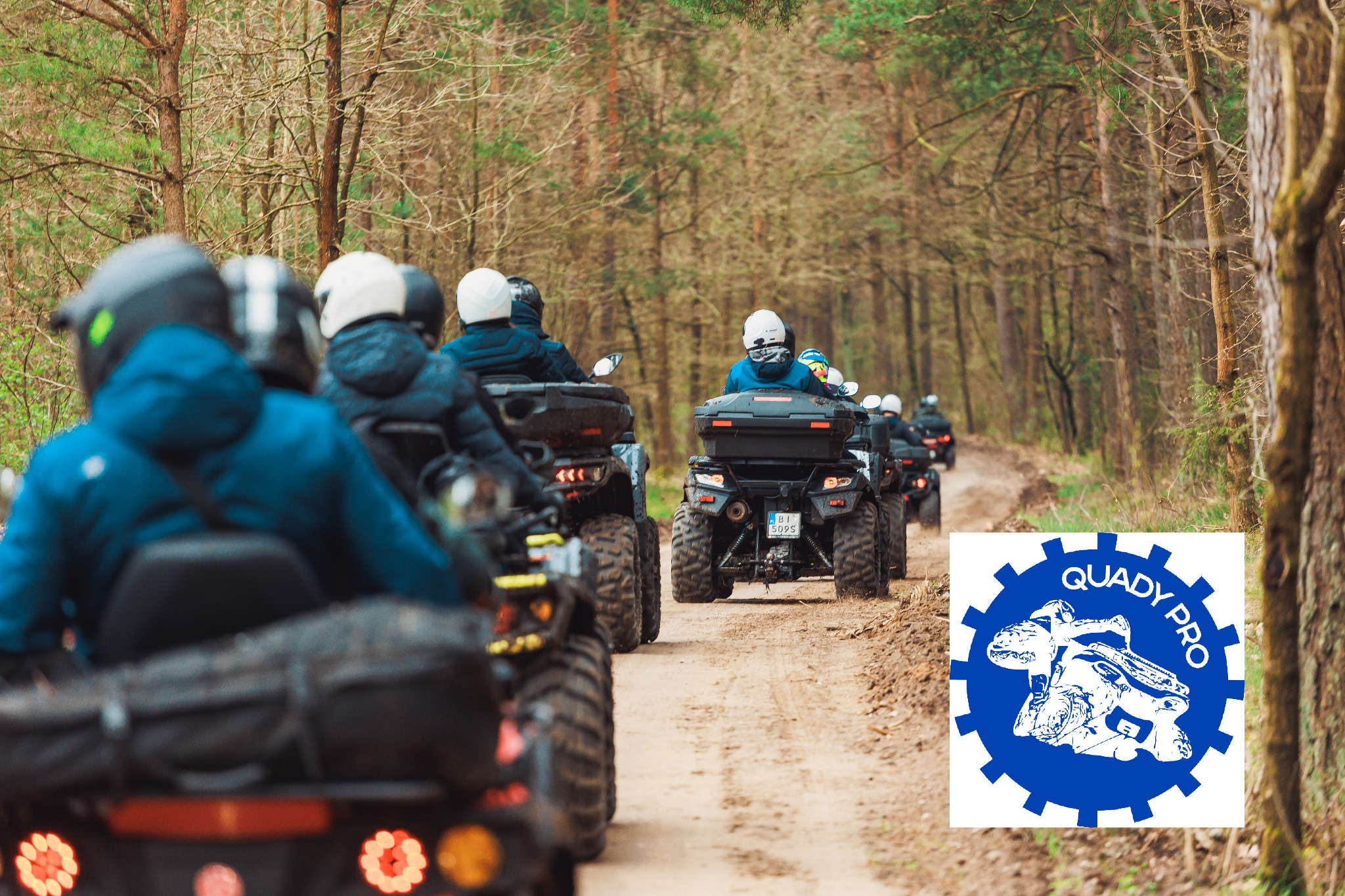 Grupa osób w kaskach na quadach w lesie, widok z tyłu, logo Quady Pro w prawym dolnym rogu.