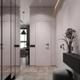 Wnętrze nowoczesnego mieszkania: minimalistyczny przedpokój z szarymi ścianami, marmurową podłogą, lustrem, konsolą z dekoracyjnym bukietem i widokiem na jadalnię z czarną lampą wiszącą.