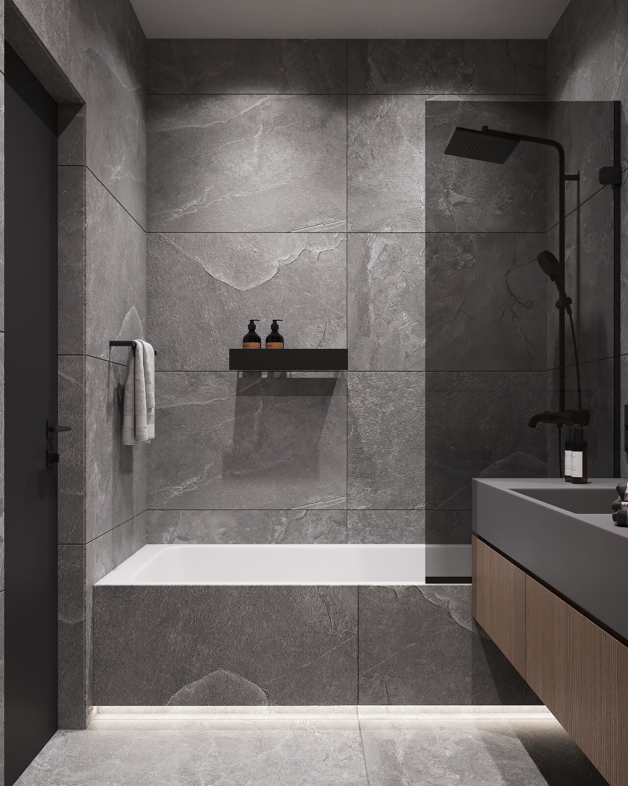 Nowoczesna łazienka z szarymi płytkami imitującymi kamień, białą wanną z podświetleniem LED u dołu, czarną armaturą i umywalką z szafką z drewnianymi lamelami.