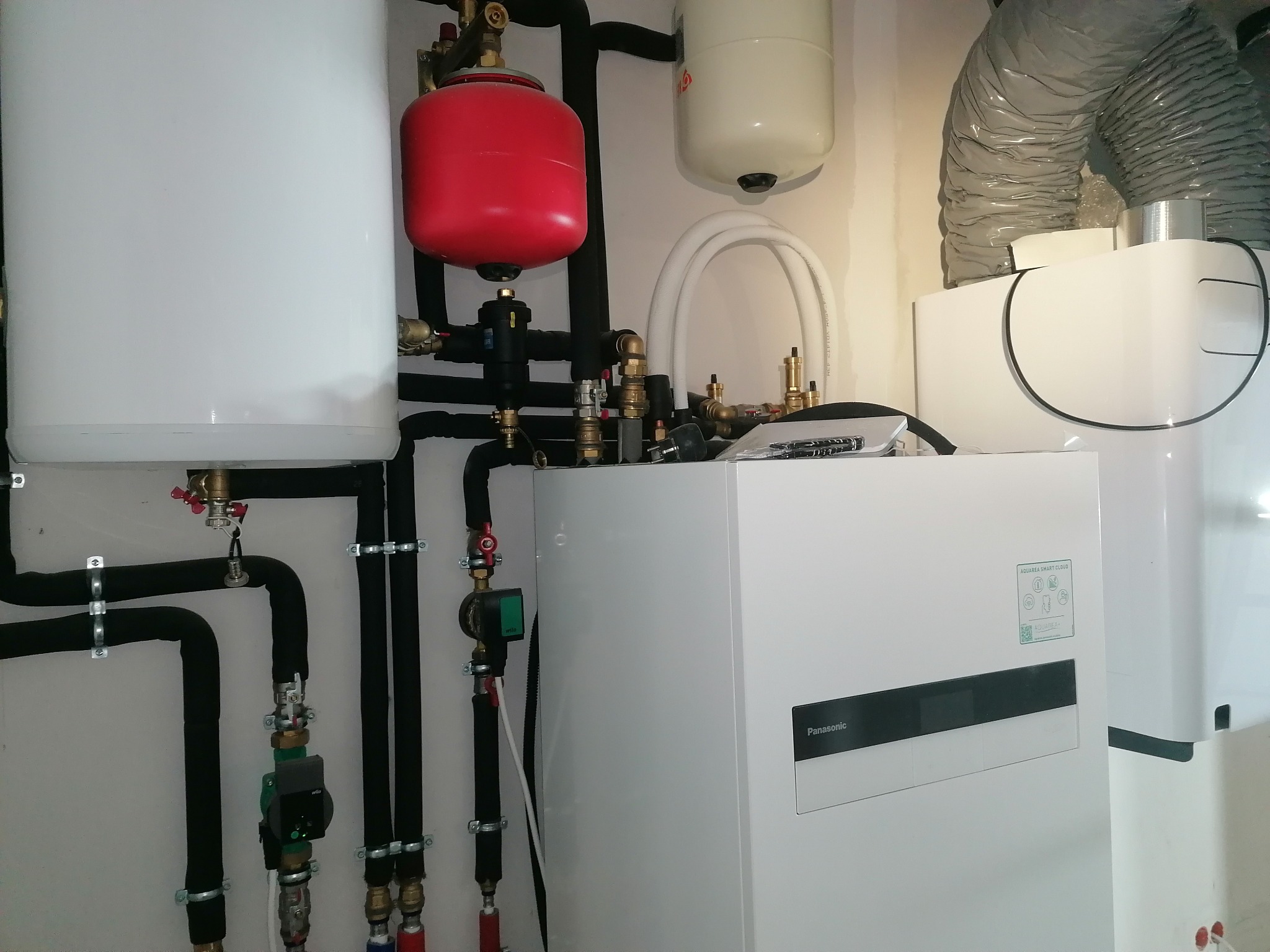 Zmontowana instalacja pompy ciepła Panasonic Aquarea w Bolestraszycach. Widoczne rury, zbiorniki wyrównawcze i jednostka wewnętrzna. Estetyczny montaż.