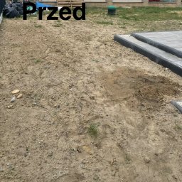 Usługi Czyszczące Robert Minikowski - Zdjęcie ogrodu w fazie przygotowawczej: ziemia, widoczne ślady prac ziemnych, fragment kostki brukowej i ogrodzenia. Ujęcie z góry, dzień.