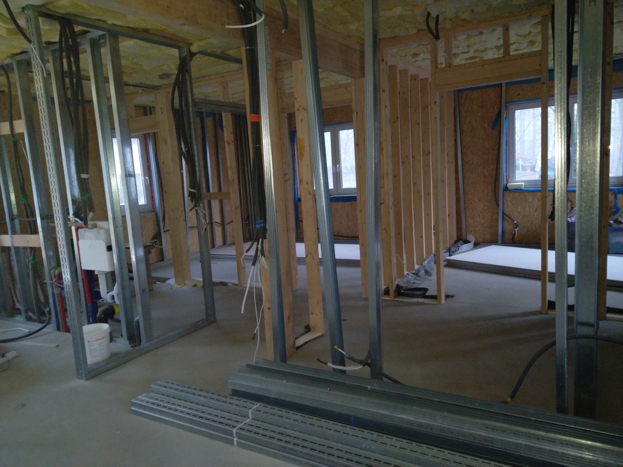 Konstrukcja szkieletowa ścian działowych z profili metalowych i drewnianych łat, widoczne instalacje, przygotowanie do montażu płyt karton-gips.