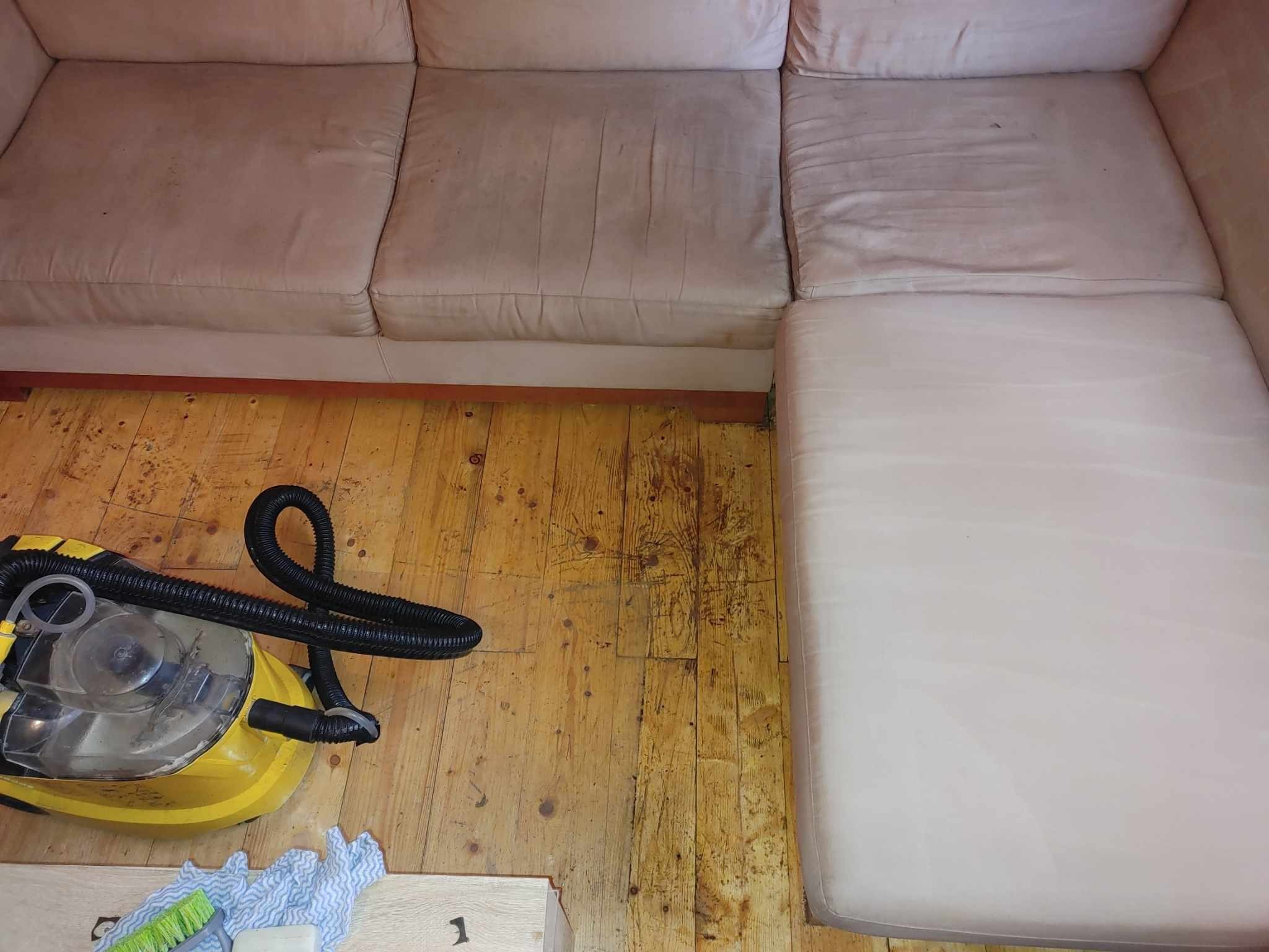 Beżowa, brudna sofa modułowa przed czyszczeniem, widoczny odkurzacz piorący Karcher, szmatki i szczotka na drewnianej podłodze.