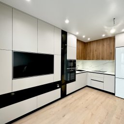 Stasacucine - Nowoczesna kuchnia z białymi szafkami, drewnianymi akcentami i czarnymi elementami dekoracyjnymi, wbudowanym telewizorem i oświetleniem punktowym.