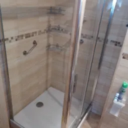 Kabina prysznicowa z brodzikiem i p&oacute;łkami narożnymi w Elblągu, widoczny uchwyt dla niepełnosprawnych.