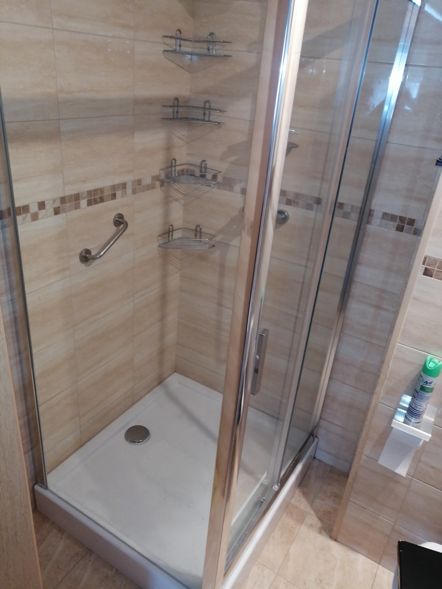 Kabina prysznicowa z brodzikiem i półkami narożnymi w Elblągu, widoczny uchwyt dla niepełnosprawnych.