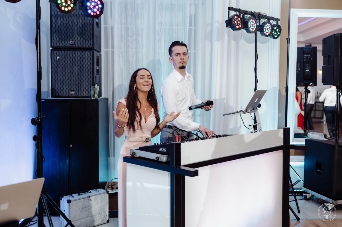 DJ i wokalistka podczas występu na imprezie w Gdyni, widoczne nagłośnienie, oświetlenie i sprzęt DJ-ski.