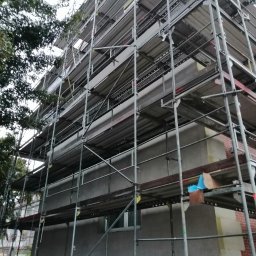 Zakład ogolnobudowlany Rzepka Tomasz Stanisław - Budynek w trakcie prac elewacyjnych, z widocznym rusztowaniem i fragmentami ocieplenia oraz nowej elewacji.