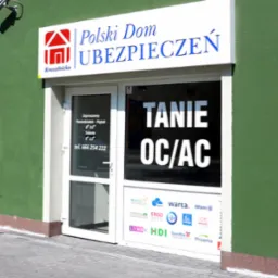 Wejście do biura ubezpieczeniowego 'Polski Dom Ubezpieczeń' z napisem 'Tanie OC/AC' na szybie i logo różnych towarzystw ubezpieczeniowych, takie jak Wiener, MTU, Warta, Allianz, Compensa, Ergo...